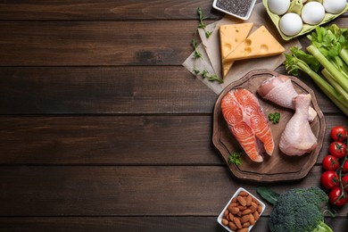 Flat lay composition with keto diet products on wooden table, space for text