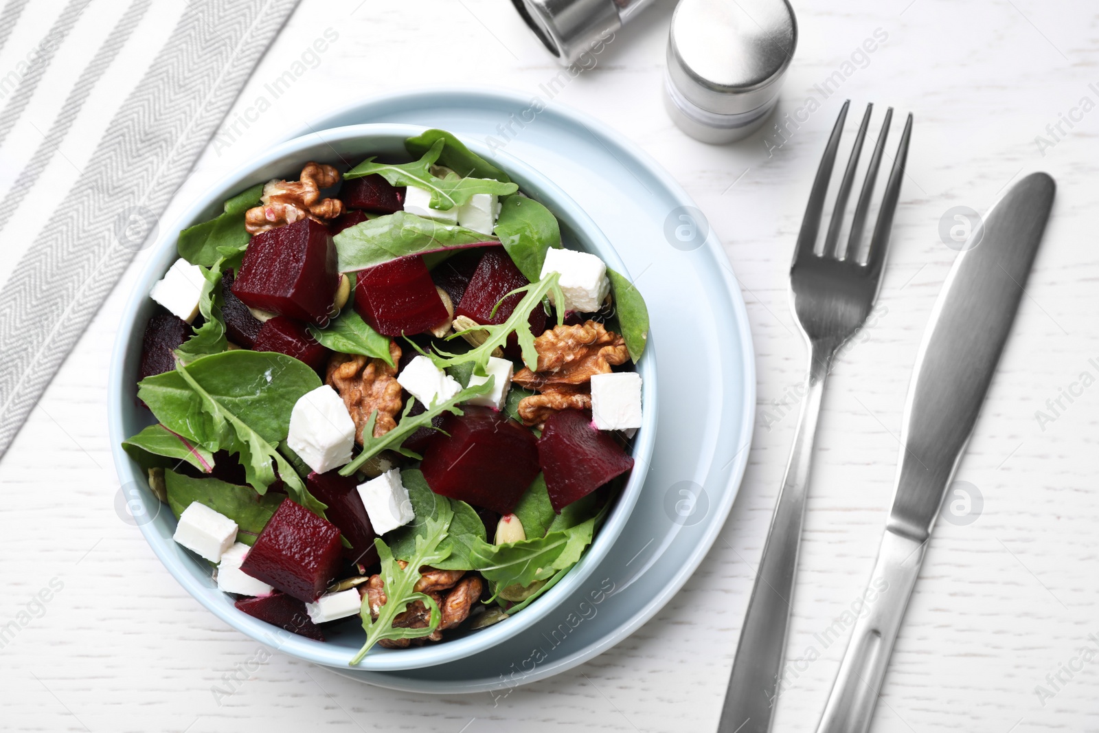 Photo of Delicious beet salad served on white wooden table, flat lay