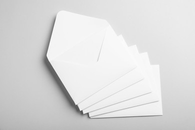 Photo of Many white paper envelopes on light grey background, flat lay
