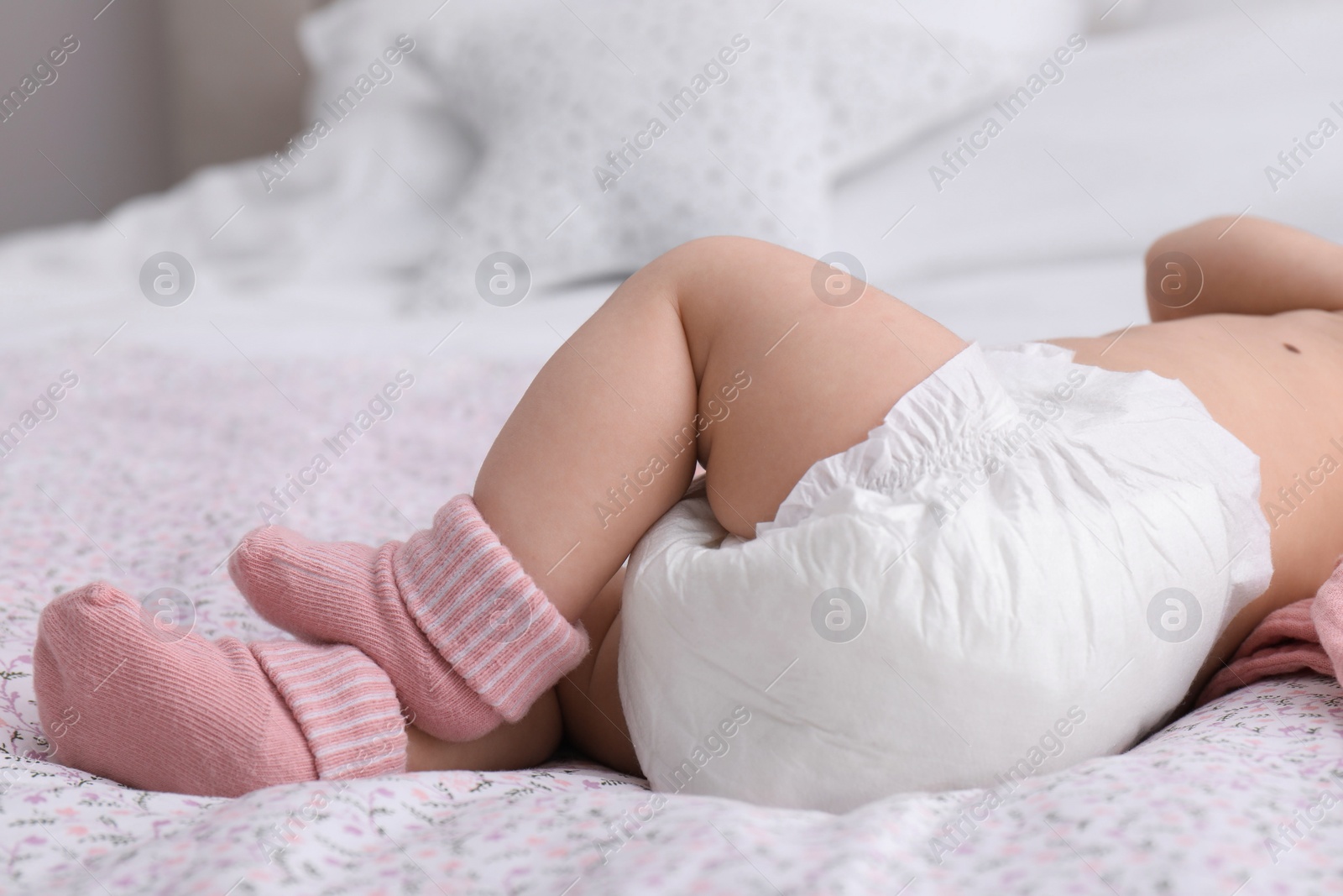 Photo of Little baby in diaper on bed, closeup