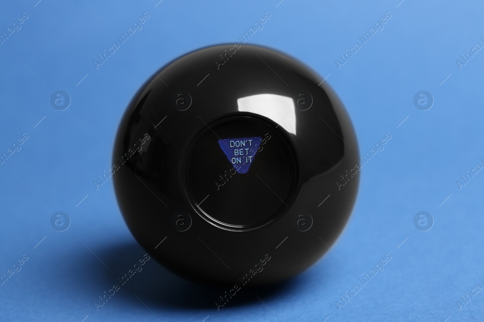 Photo of Magic eight ball with prediction Donʼt Bet On It on blue background