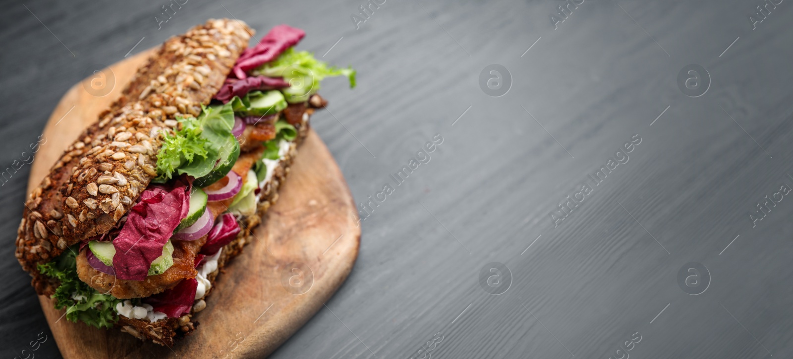 Image of Delicious sandwich with schnitzel on grey wooden table, banner design. Space for text