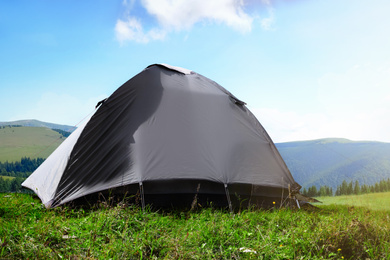 Image of Grey camping tent in mountains on sunny day