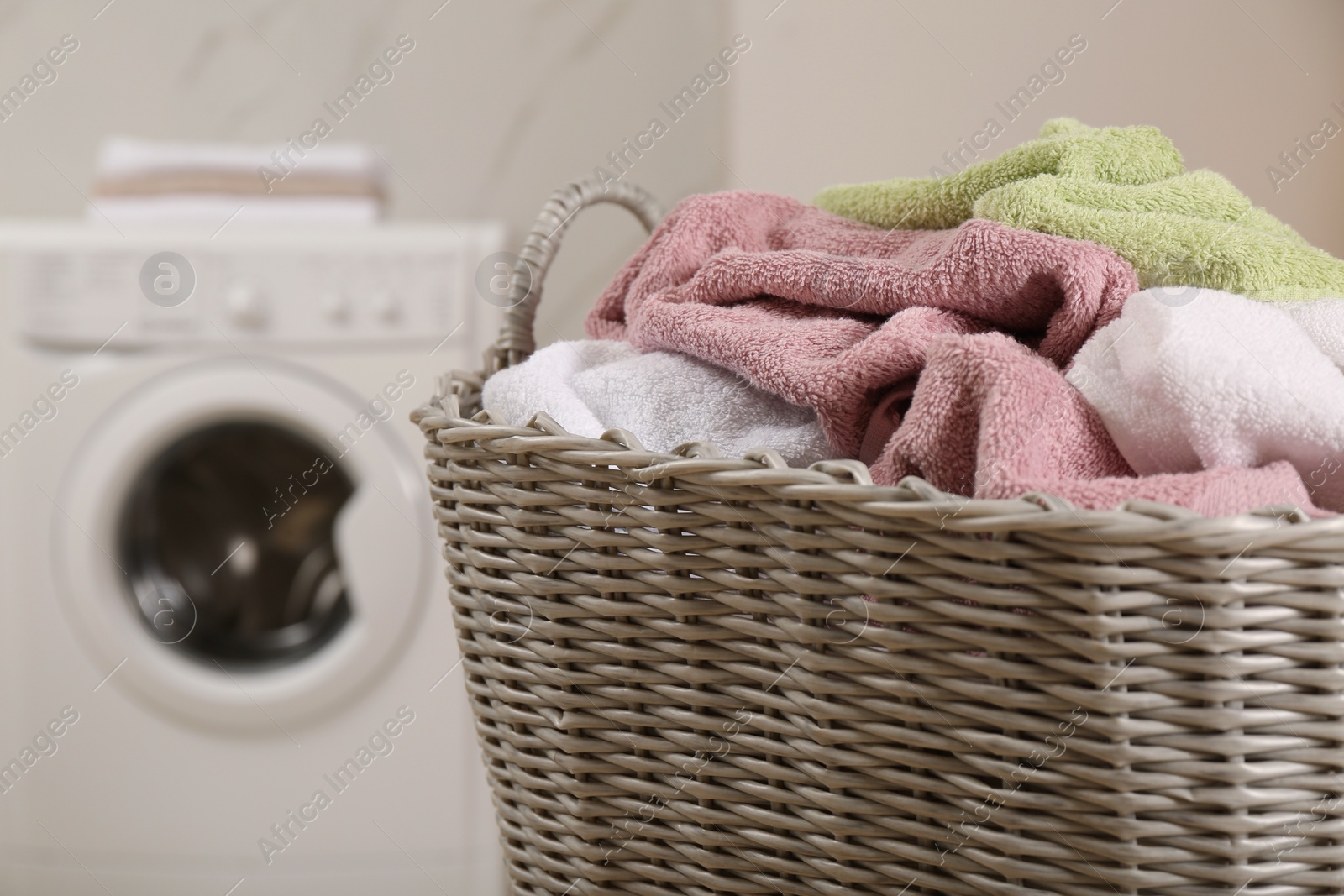 Photo of Wicker basket with dirty laundry in bathroom, closeup