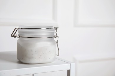 Jar of salt scrub on white table. Space for text