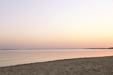 Photo of Sandy beach near sea at summer sunset