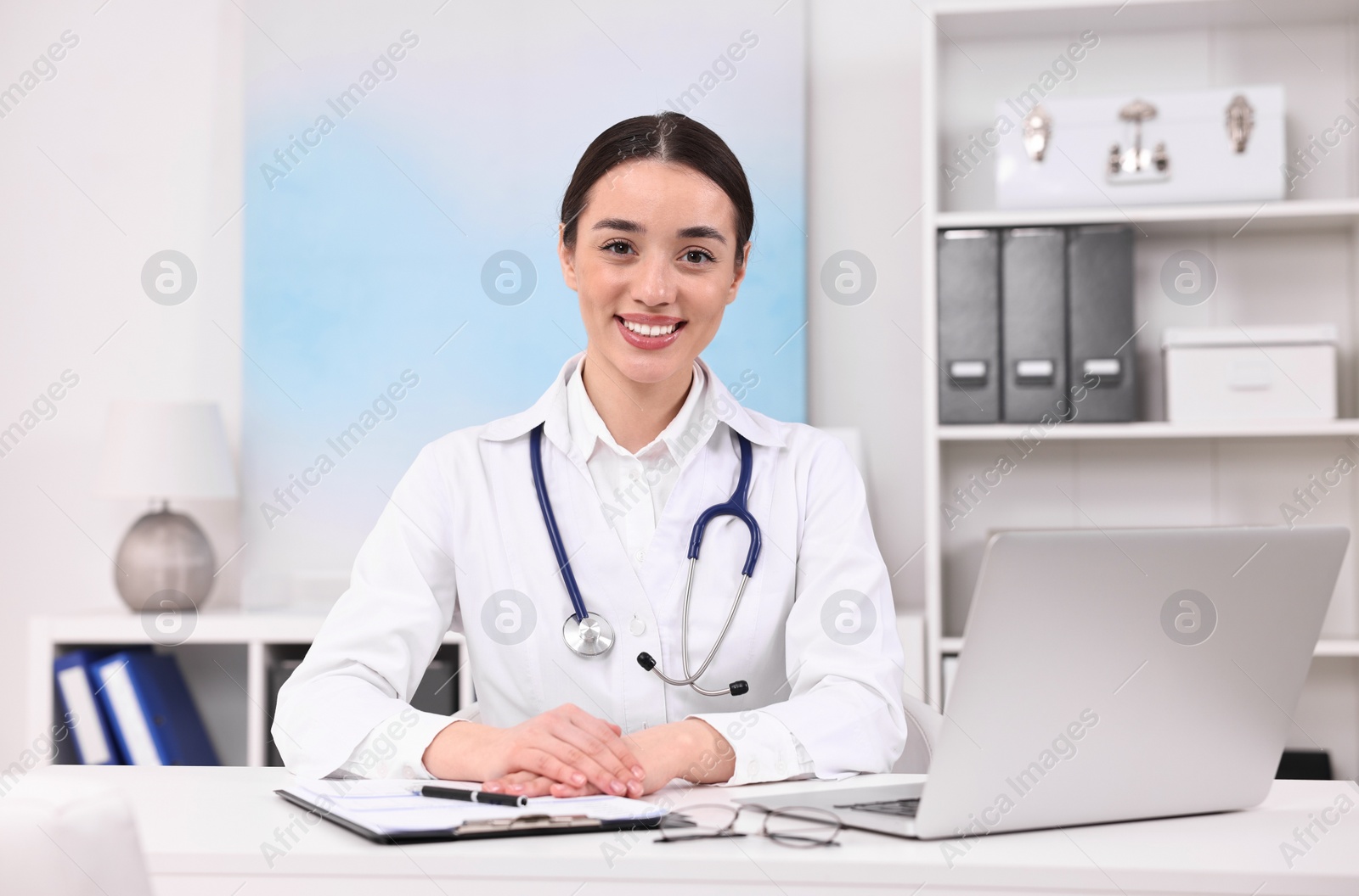 Photo of Medical consultant with stethoscope at table in clinic