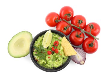 Photo of Delicious guacamole with nachos chips, lime and different ingredients isolated on white, top view