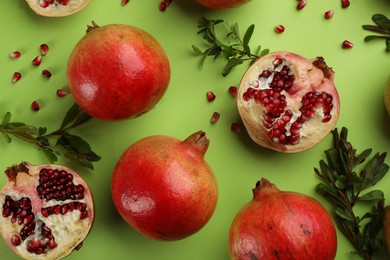 Photo of Flat lay composition with ripe pomegranates on green background