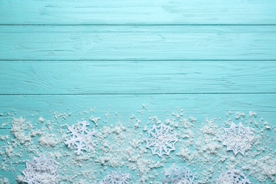 Flat lay composition with snowflakes on blue wooden background, space for text. Winter season