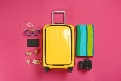 Photo of Flat lay composition with suitcase and traveler's accessories on color background