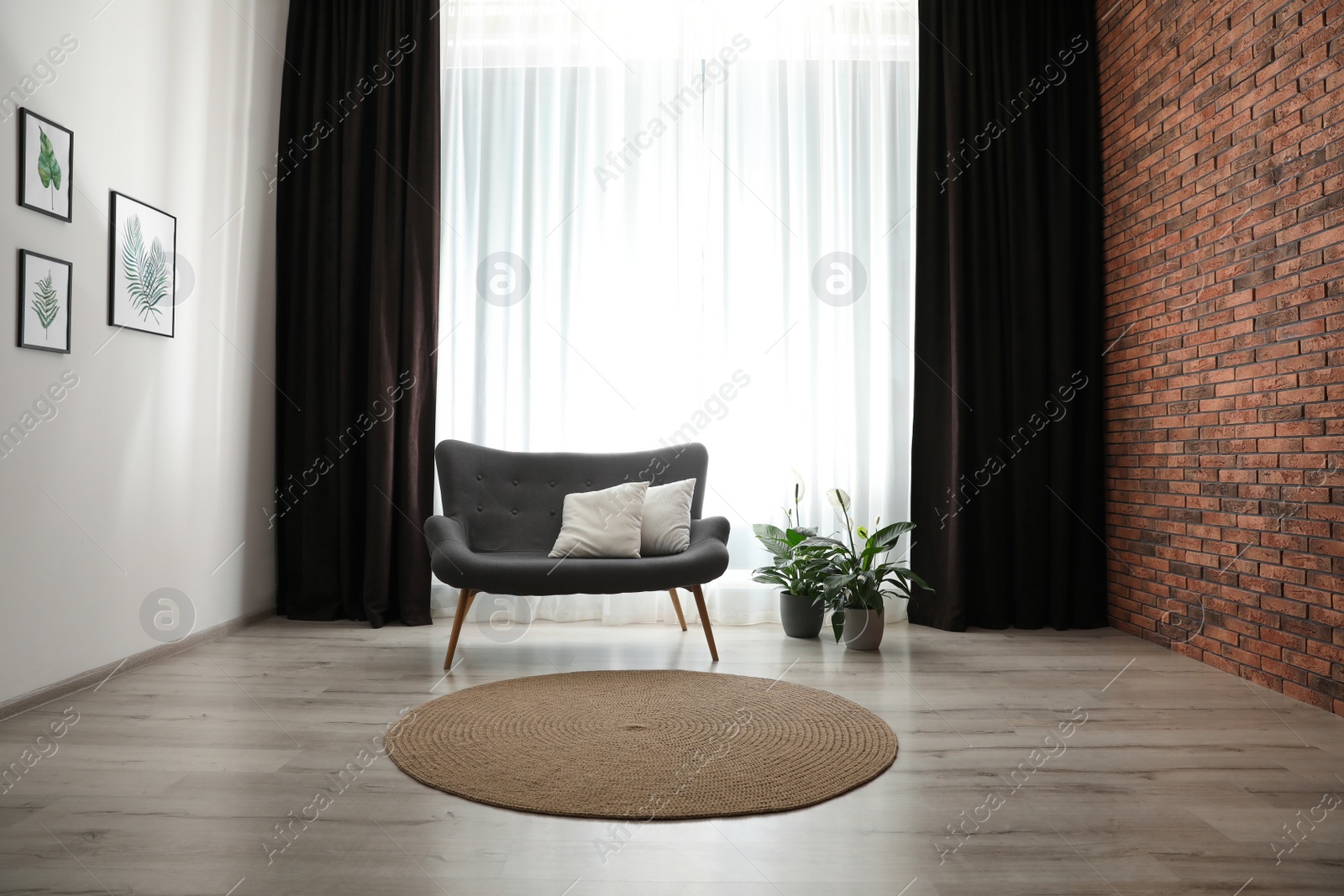 Photo of Comfortable sofa near window with elegant curtains in room