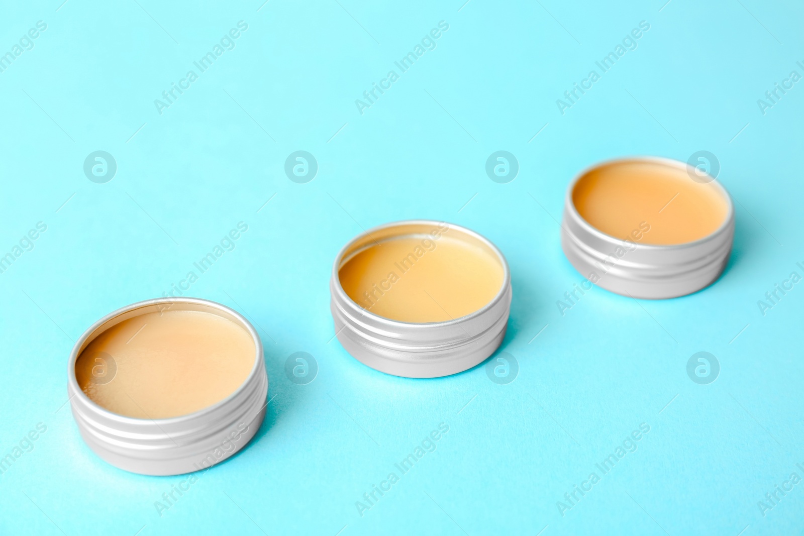 Photo of Lip balms on color background, closeup