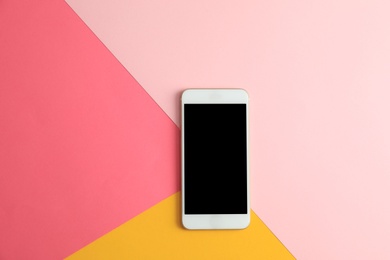 Photo of Modern phone on color background, top view. Space for text