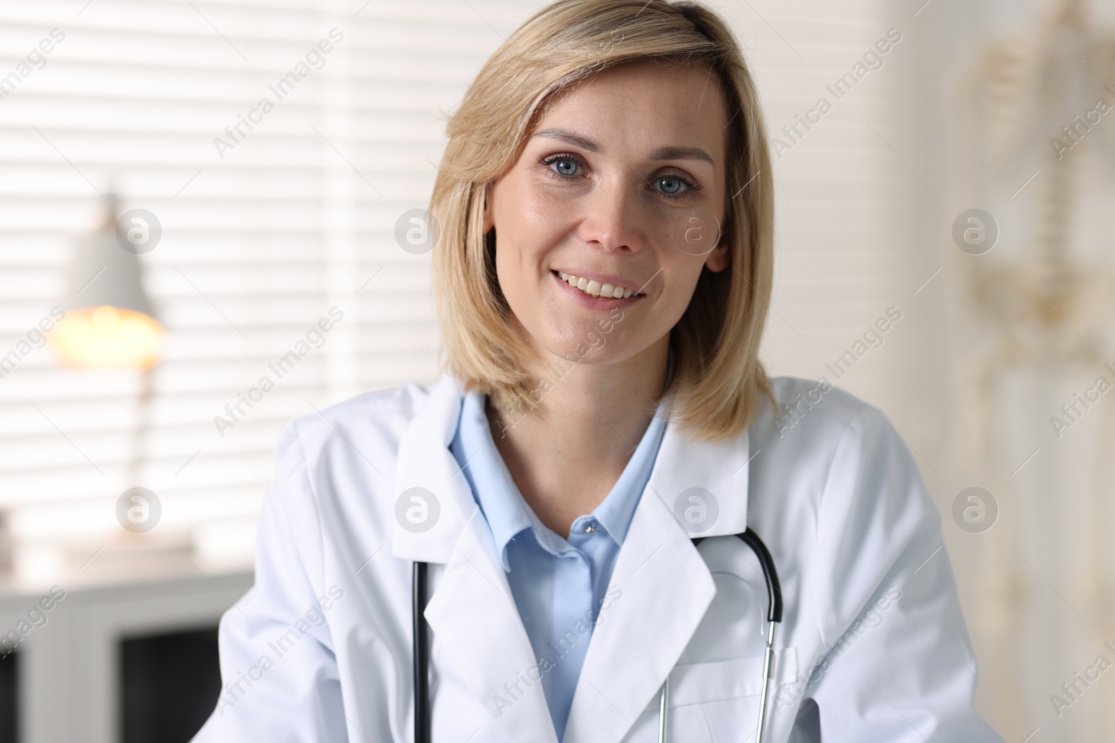 Photo of Portrait of smiling doctor on blurred background