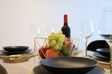 Photo of Bottle of wine and fruits on table served for dinner indoors