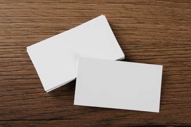 Photo of Blank business cards on wooden background, flat lay. Mockup for design