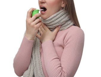 Woman using throat spray on white background, closeup