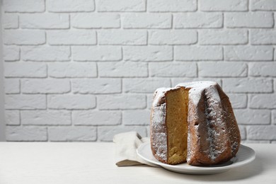 Delicious Pandoro cake decorated with powdered sugar on white table, space for text. Traditional Italian pastry