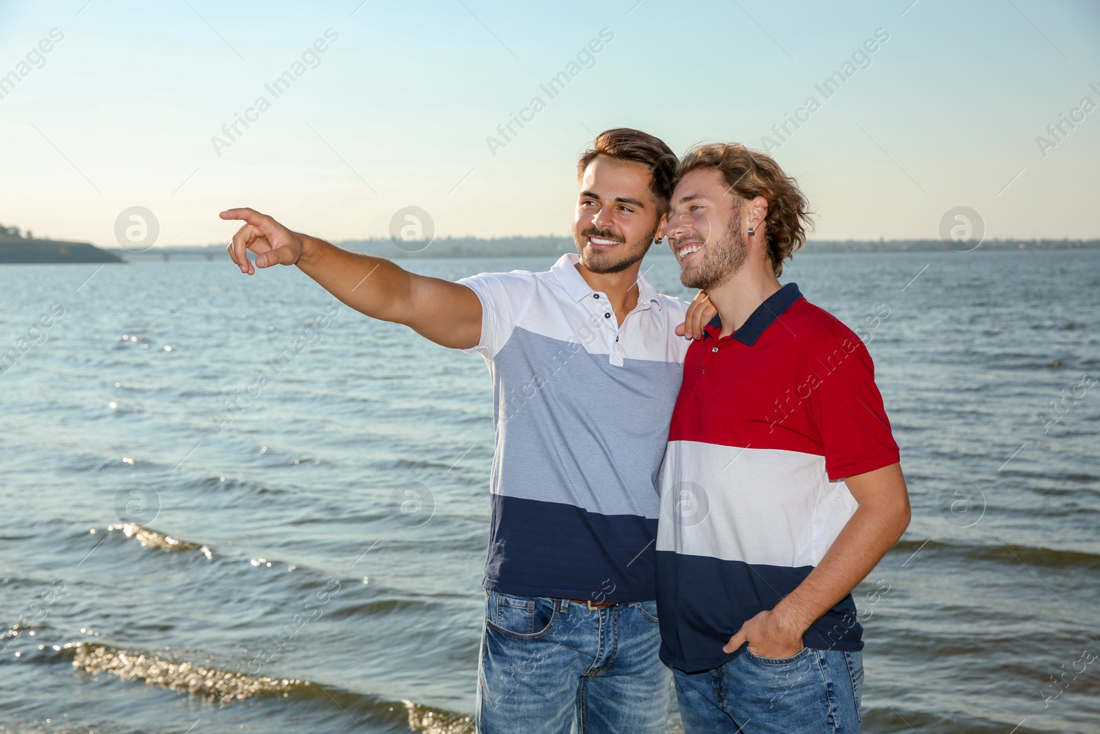 Photo of Happy gay couple standing together at riverside