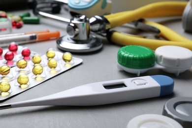 Photo of Thermometer and other medical objects on grey table