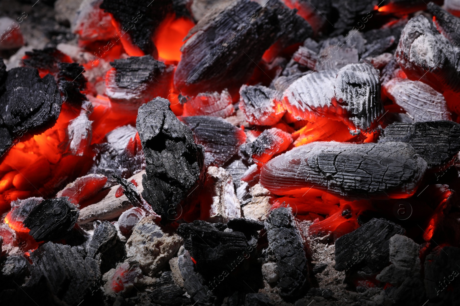 Photo of Pieces of hot smoldering coal as background, closeup