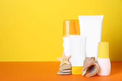Photo of Different suntan products, seashells and starfish on color background. Space for text