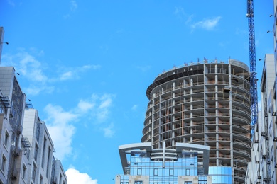 Photo of Unfinished building against blue sky. Construction safety rules