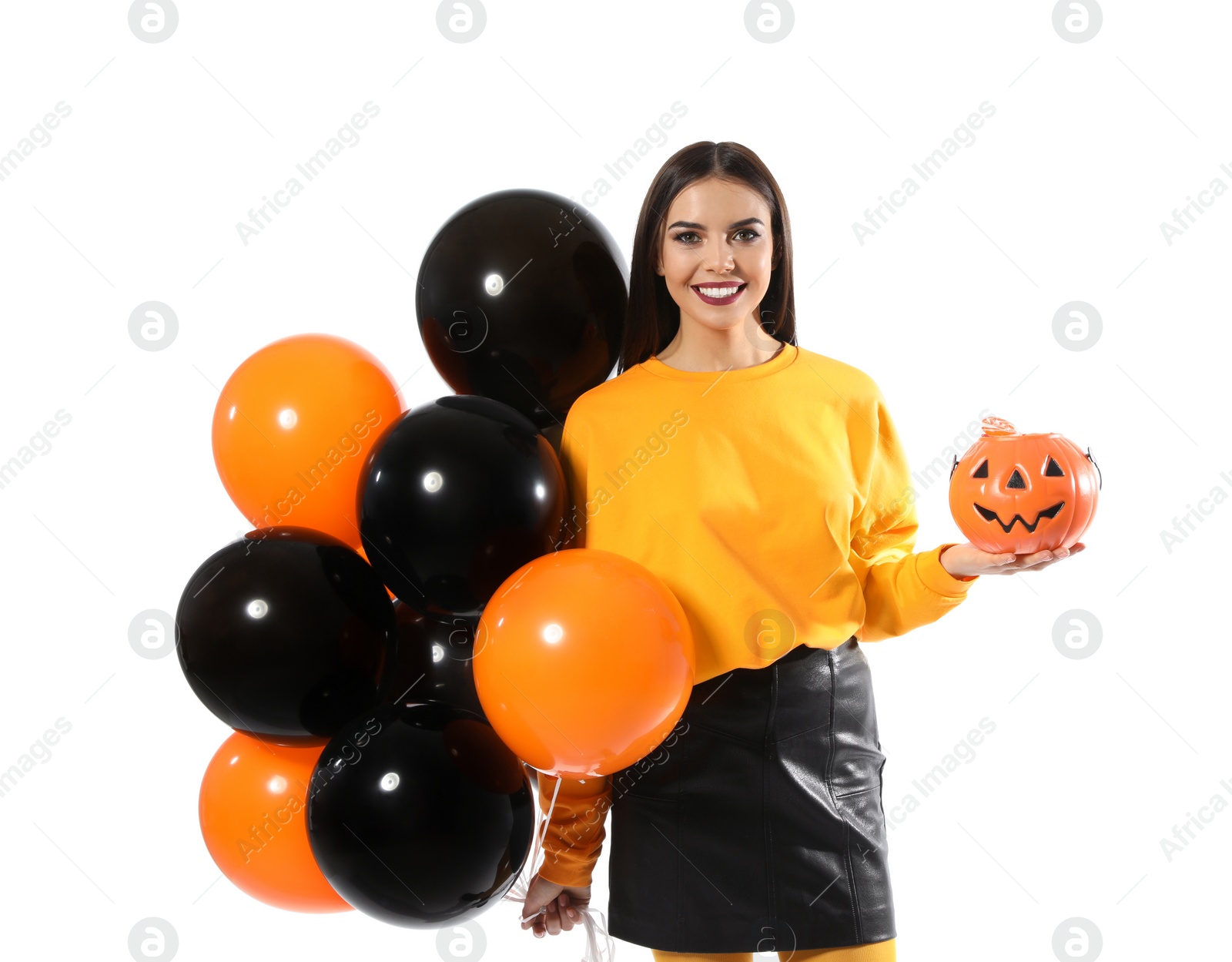 Photo of Beautiful woman with balloons and Jack O'Lantern candy container on white background. Halloween party