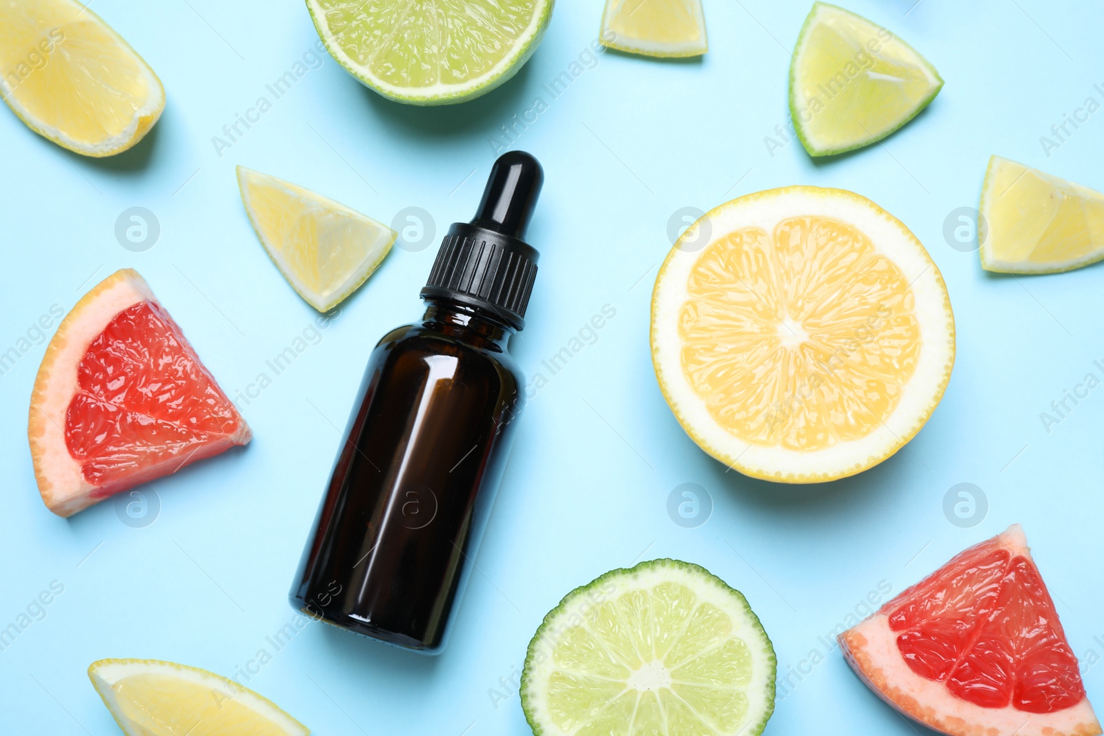 Photo of Flat lay composition with citrus essential oil on light blue background