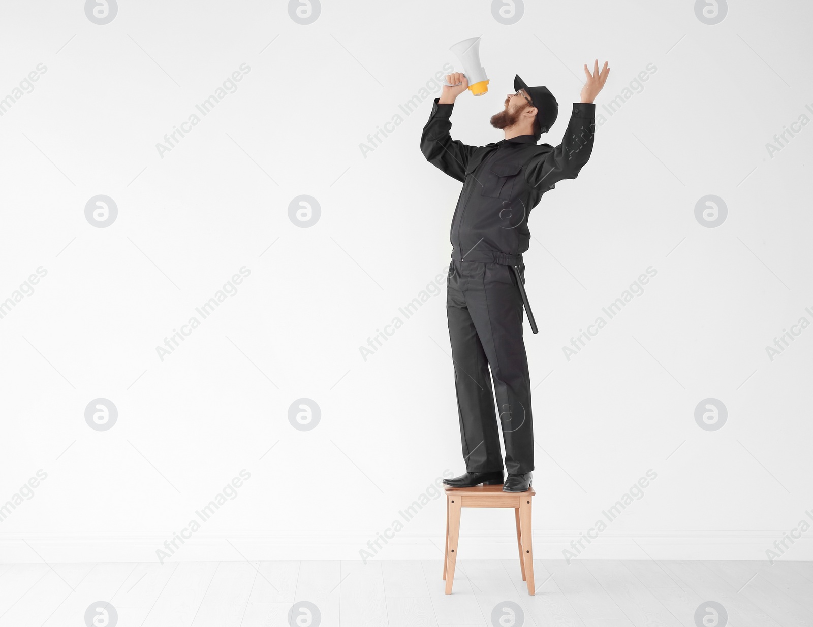 Photo of Security guard shouting into megaphone indoors