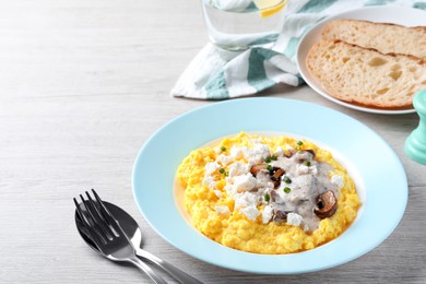 Tasty banosh served with brynza and mushrooms on light wooden table, space for text. Traditional Ukrainian dish