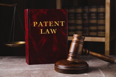 Patent Law book and gavel on grey marble table