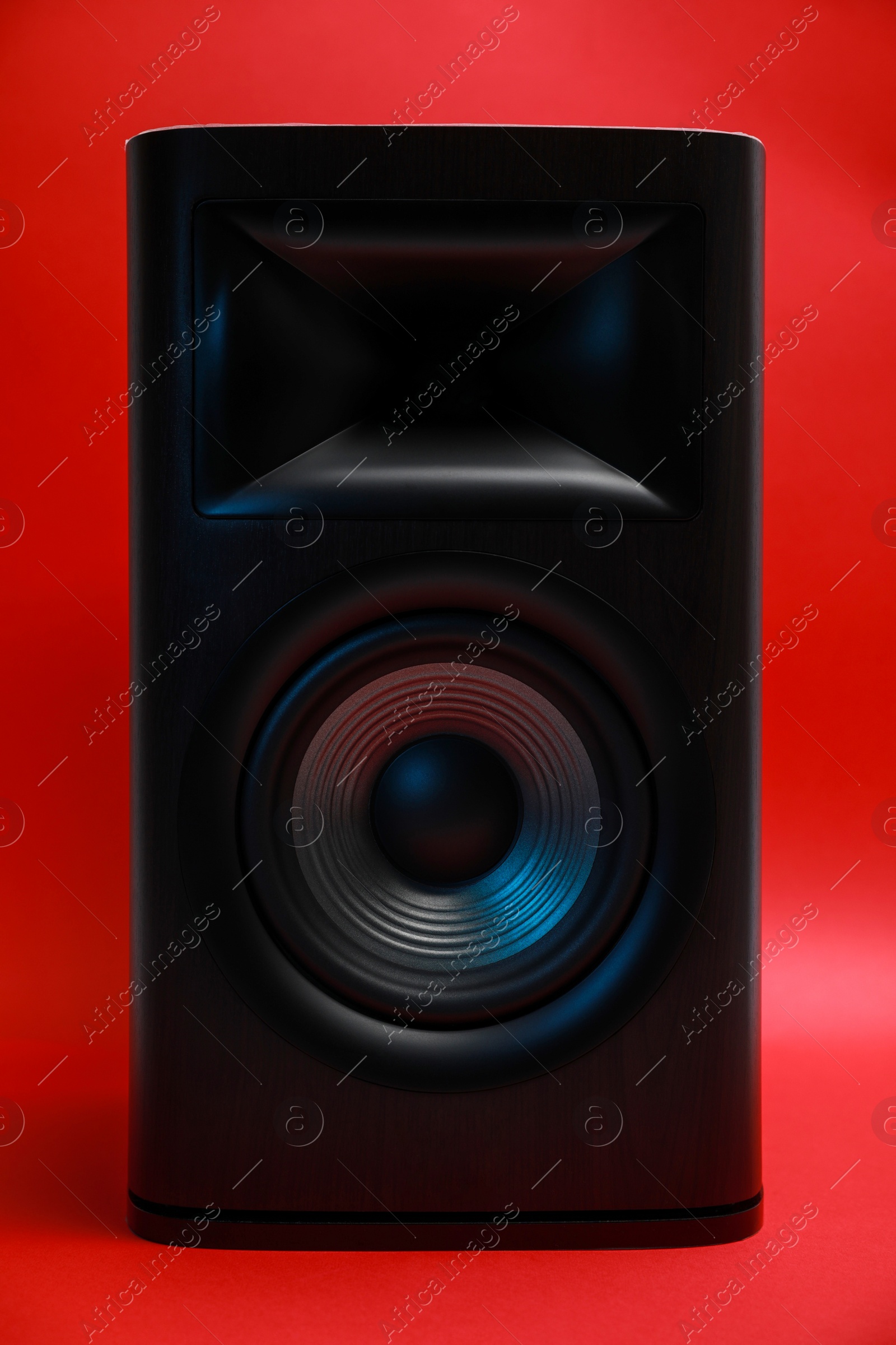 Photo of One wooden sound speaker on red background