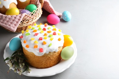 Photo of Beautiful Easter cake and painted eggs on light grey table. Space for text