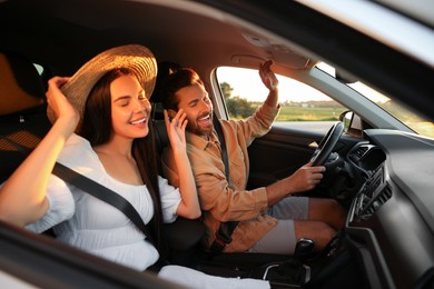 Photo of Happy couple enjoying trip together by car, view from outside