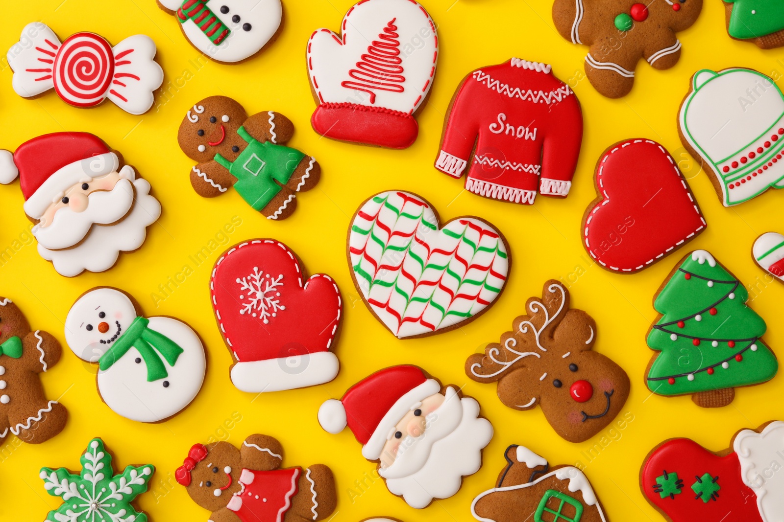 Photo of Different Christmas gingerbread cookies on yellow background, flat lay