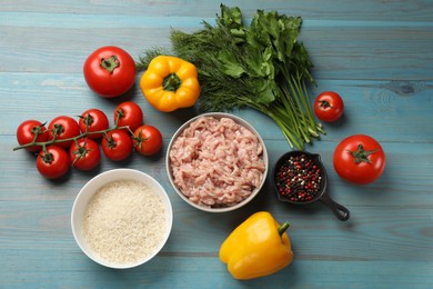 Photo of Making stuffed peppers. Ground meat and other ingredients on light blue wooden table, flat lay
