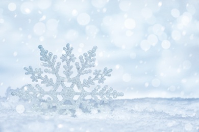 Image of Beautiful decorative snowflake on white snow. Space for text