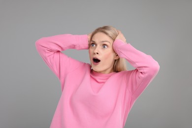 Photo of Portrait of surprised woman on grey background