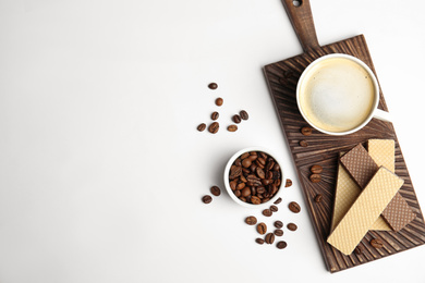 Breakfast with delicious wafers and coffee on white background, flat lay. Space for text