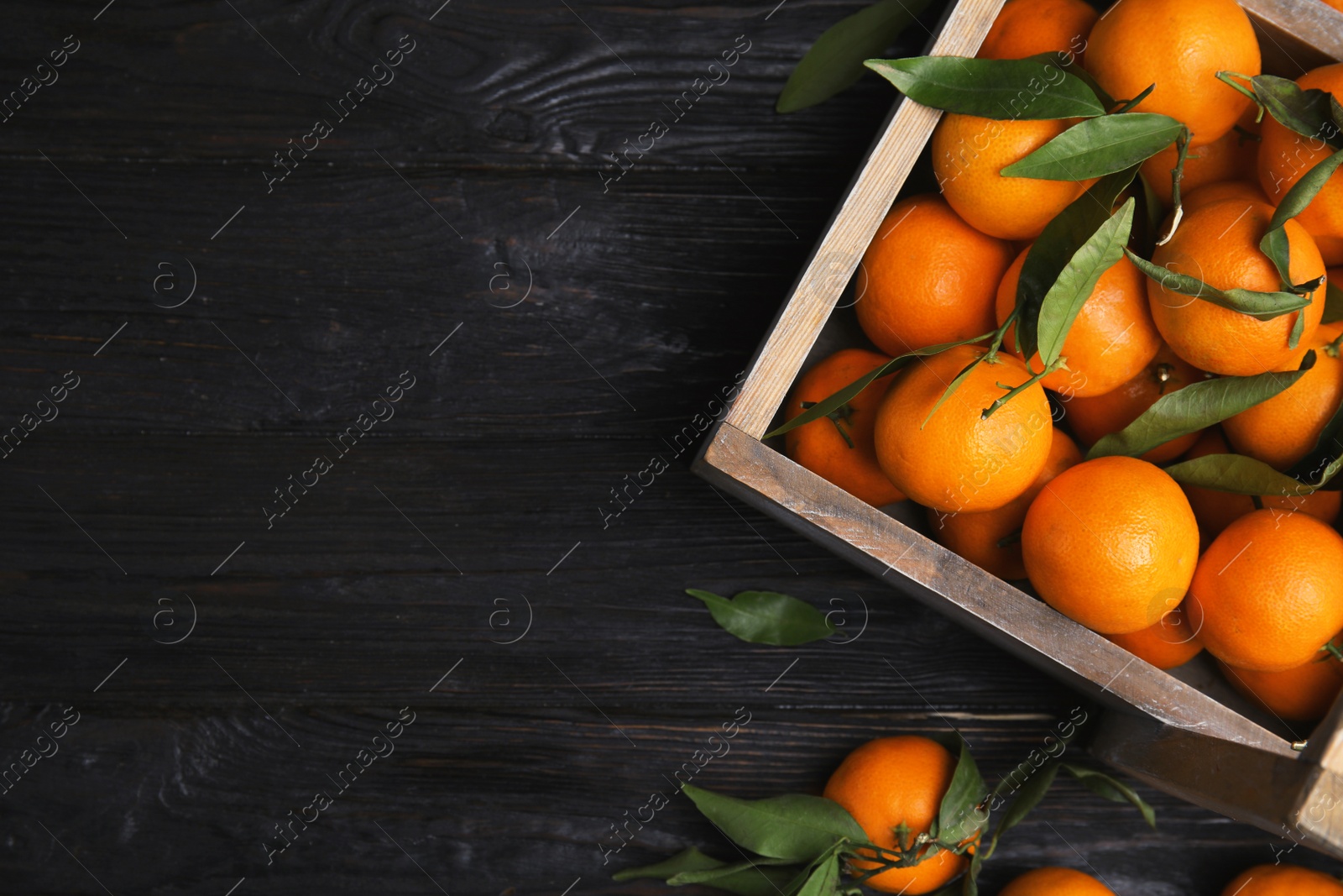 Photo of Crate with fresh ripe tangerines and space for text on wooden background, top view