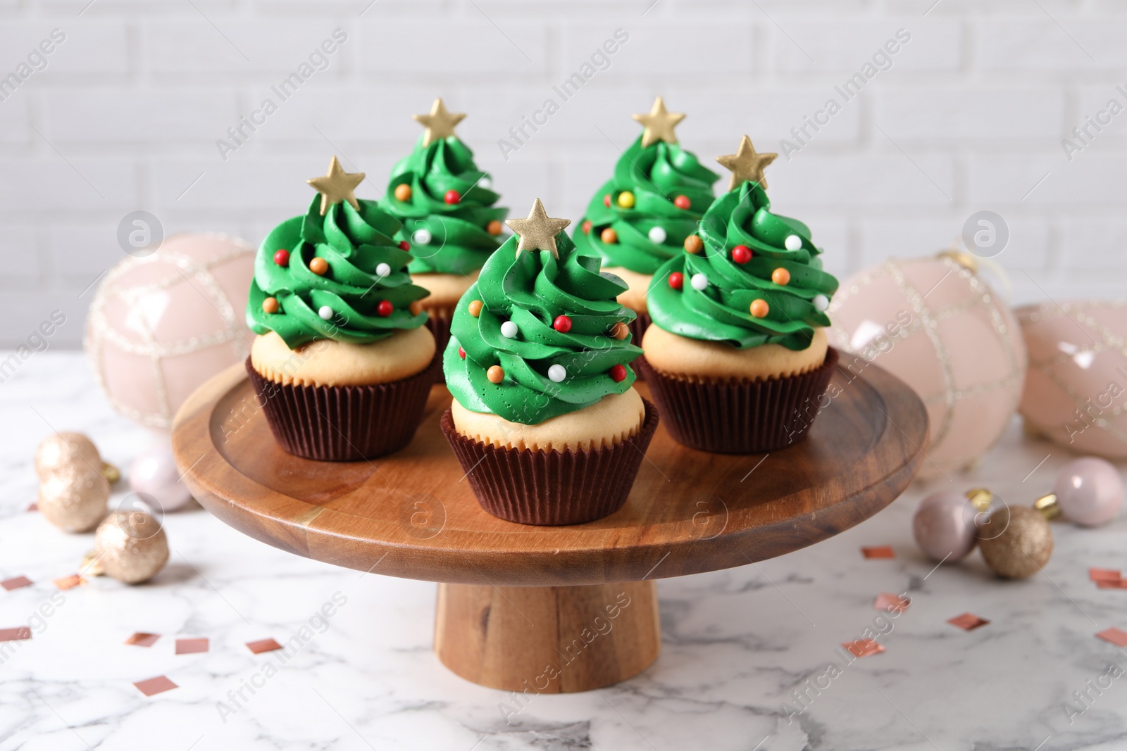 Photo of Christmas tree shaped cupcakes on white marble table