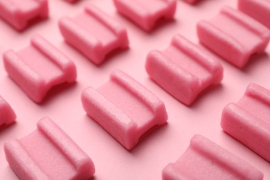 Photo of Tasty chewing gums on pink background, closeup