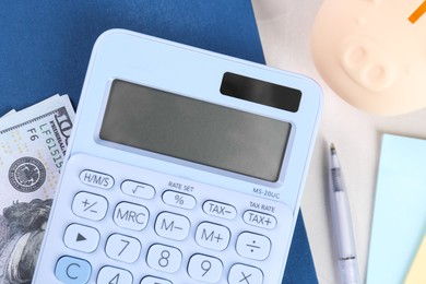 Calculator, dollar banknote, notebook, pen and piggy bank on light gray table, flat lay. Retirement concept