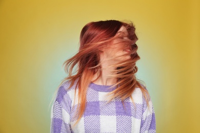 Photo of Young woman with bright dyed hair on yellow background