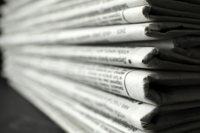 Photo of Stack of newspapers on table, closeup. Journalist's work