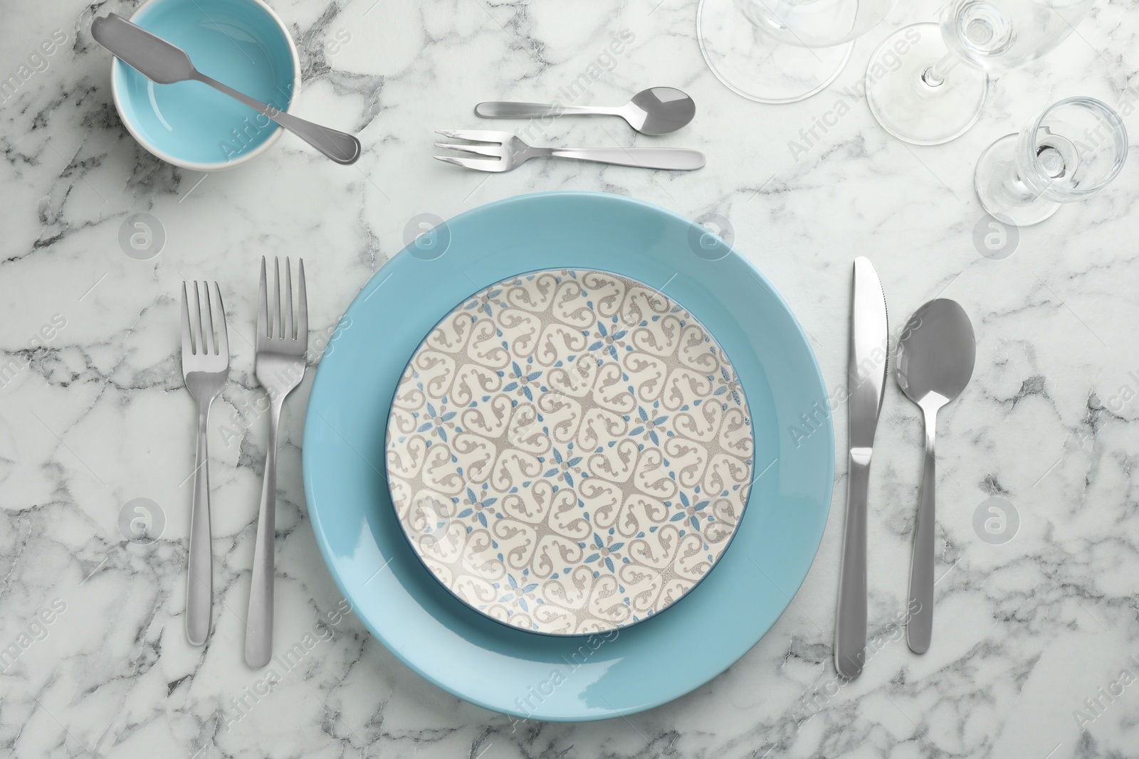 Photo of Stylish setting with cutlery and plates on white marble table, flat lay