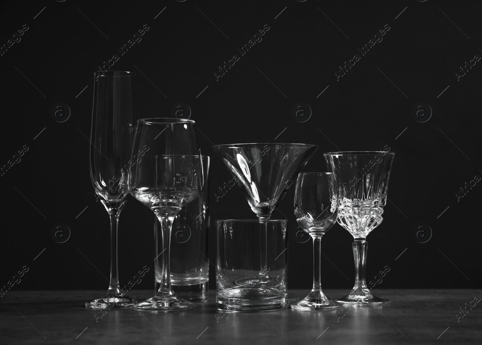 Photo of Set of bar glassware on table against dark background