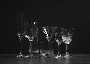 Set of bar glassware on table against dark background